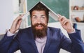 Funny teacher with laptop notebook in classroom at school. Excited teacher professor with laptop on head wearing formal Royalty Free Stock Photo