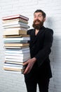 Funny teacher or professor with book stack. Thinking serious mature teacher. Falling books concept. Mature professor