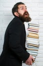 Funny teacher or professor with book stack. Thinking serious mature teacher. Falling books concept. Mature professor