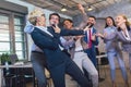 Teambuilding indoors activity. Business people making team training exercise during team building seminar singing karaoke Royalty Free Stock Photo