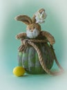 Funny teddy Easter rabbit look out from flower pot.