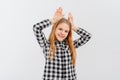 Funny teen girl standing over white background doing bunny ears gesture with hands palms looking happy and glad. Easter rabbit Royalty Free Stock Photo