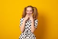 Funny teenage girl with a two-ponytail hairstyle smiles with braces grimaces and laughs on a yellow background Royalty Free Stock Photo