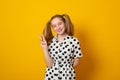 Funny teenage girl with a two-ponytail hairstyle smiles with braces grimaces and laughs on a yellow background Royalty Free Stock Photo