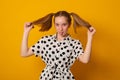 Funny teenage girl with a two-ponytail hairstyle smiles with braces grimaces and laughs Royalty Free Stock Photo