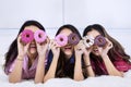 Funny teenage girls with donuts at sleepover party