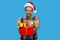 Funny teenage guy handing Christmas gift boxes. Royalty Free Stock Photo