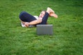 Funny teenager girl trying to practice yoga lesson first time online at home in garden using laptop during quarantine self isolati