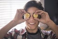 Funny teenager playing and joking with 2 bitcoins on his eyes - future payment and money concept