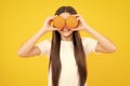 Funny teenager portrait. Happy teenager girl hold grapefruit orangeisolated on yellow background, kids fruits vitamin.