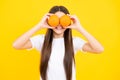 Funny teenager portrait. Happy teenager girl hold grapefruit orangeisolated on yellow background, kids fruits vitamin.