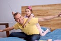 Funny time. Happy father& x27;s day. Dad and his child daughter are playing at home on bed