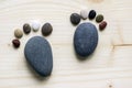 Funny tiny stone feet and ten toes on wooden background, stone in the shape of a human feet Royalty Free Stock Photo