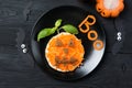 Funny toast with carrots in a shape of pumpkin, sandwich for kids Halloween idea, top view on wooden background