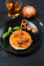 Funny toast with carrots in a shape of pumpkin, sandwich for kids Halloween idea, wooden background