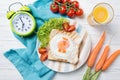 Funny toast with fried egg in a shape of chicken and alarm clock, food for kids Easter idea, top view