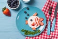 Funny toast in a shape of fish, sandwich with cream cheese and berries, food for kids idea, top view