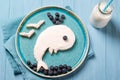 Funny toast in a shape of whale, sandwich with cream cheese and blueberries, food for kids idea, top view