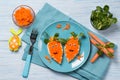 Funny toasts in a shape of carrots, food for kids Easter idea, top view