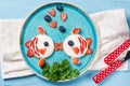 Funny toasts in a shape of kissing fishes, sandwich with cream cheese and berries, food for kids idea, top view