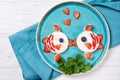 Funny toasts in a shape of kissing fishes, sandwich with cream cheese and berries, food for kids idea, top view