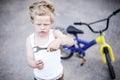 Funny toddler boy repairing his broken bike. Childhood.Cycling