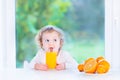 Funny toddler girl drinking orange juice Royalty Free Stock Photo