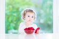 Funny toddler girl eating raspberries at white table Royalty Free Stock Photo