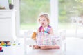 Funny toddler girl feeding her toy bear in sunny room Royalty Free Stock Photo