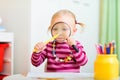 Funny toddler girl playing with magnifier Royalty Free Stock Photo