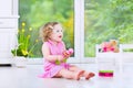 Funny toddler girl playing maracas in white room