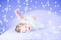 Funny toddler girl in a white dress between Christmas lights Royalty Free Stock Photo