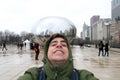 Funny tourist at Cloud gate at Chicago Illinois Bean mirror art with people and buildings. Royalty Free Stock Photo