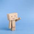 Funny toy cardboard robot on blue background