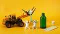 Funny toy kittens and forklift transport a teaspoon to an open green bottle of medicinal syrup. Game concept for accustoming Royalty Free Stock Photo