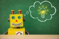 Funny toy robot teacher against chalkboard Royalty Free Stock Photo