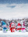 Funny toy snowmen in the open space during a snowfall. Christmas and New Year greeting card