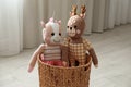 Toy unicorn and deer in basket on floor. Decor for children`s room interior