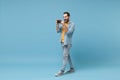 Funny traveler tourist man in summer casual clothes with photo camera on neck on blue background. Male