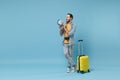 Funny traveler tourist man in yellow casual clothes with photo camera, suitcase isolated on blue background. Male Royalty Free Stock Photo