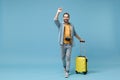 Funny traveler tourist man in yellow clothes with photo camera isolated on blue background. Male passenger traveling on Royalty Free Stock Photo