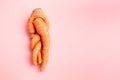 funny ugly twisted carrot on pink background.