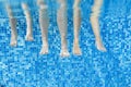 Funny underwater family legs in swimming pool, under water view of mother and kids, vacation fitness Royalty Free Stock Photo