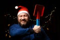 Funny unshaven man in New Years hat with a toy shovel in his hand Royalty Free Stock Photo