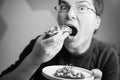 Funny Upclose view of caucasian woman eating avocado toast looking into camera, horizontal black and white shot