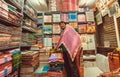 Funny vendor making presentation inside small textile store with dresses and scarfs