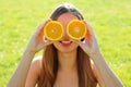 Funny Vitamin C girl. Portrait of joyful pretty lovely positive natural young woman hiding behind two halves of orange sitting in
