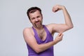 Funny weak sportsman exercising looking on his biceps