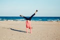 Funny white Caucasian child kid teenager, doing cartwheel playing on beach on sunset Royalty Free Stock Photo