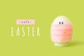 Funny white egg with eyes and mouth in medical face pink mask on green spring background. Happy Easter greeting card with text. Royalty Free Stock Photo